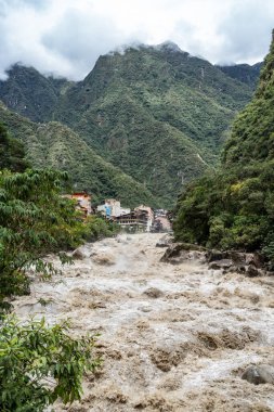Urubamba Nehri 'nin güçlü sularının Aguas Calientes' teki kutsal vadiyi geçmesiyle dramatik bir manzara.