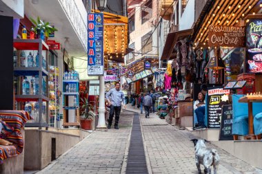 Aguas Calientes, Peru - 18 Mart 2025: Aguas Calientes 'ten yerel satıcılar, dükkanlar ve turistlerle birlikte yaya sokak sahnesi.