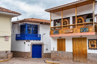 Pisac, Peru - 20 Mart 2025: Kutsal Vadi 'deki Pisac Meydanı' nda (Plaza Constitucion) geleneksel ahşap balkonlu renkli koloni binaları