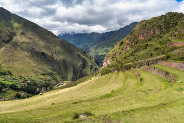 Pisac antik İnka arkeolojik sahasında dik dağ eteklerine inşa edilmiş tarımsal taş teraslarıyla manzara..