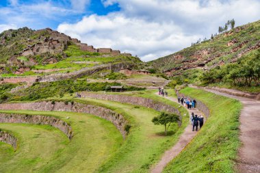 Pisac, Peru - 20 Mart 2025: Antik İnka arkeoloji sahasındaki tarım taşı terasını ziyaret eden bir grup turist.