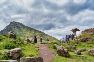 Pisac, Peru - 20 Mart 2025: Antik İnka arkeoloji sahasındaki tarım taşı terasını ziyaret eden bir grup turist