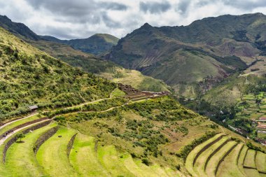 Peru 'nun Kutsal Vadisi' ndeki antik İnka arkeolojik alanı Pisac 'ın dik yamaçlarına inşa edilmiş tarımsal taş teraslarıyla manzara.