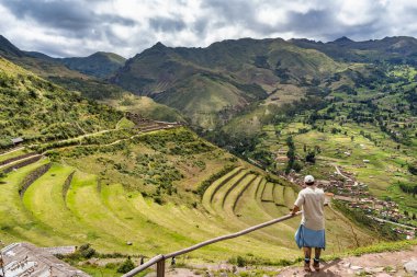 Turist, Pisac arkeoloji sahasındaki İnkalar 'ın kutsal vadisinde yemyeşil manzaranın tadını çıkarıyor..