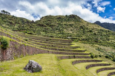 Peru 'nun Kutsal Vadisi' ndeki antik İnka arkeolojik alanı Pisac 'ın dik yamaçlarına inşa edilmiş tarımsal taş teraslarıyla manzara.