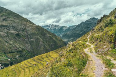 Peru 'nun Kutsal Vadisi' ndeki antik İnka arkeolojik alanı Pisac 'ın dik yamaçlarına inşa edilmiş tarımsal taş teraslarıyla manzara.