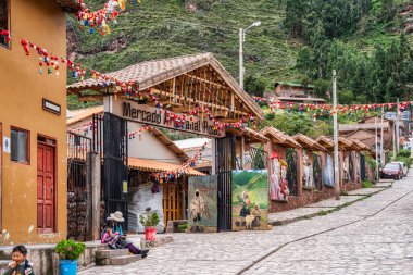 Pisac, Peru - 20 Mart 2025: Kutsal Vadi 'deki Mercado Artesanal de Pisac (Pisac Pazarı) yakınlarında dar, tarihi bir kaldırım taşı caddesi manzarası