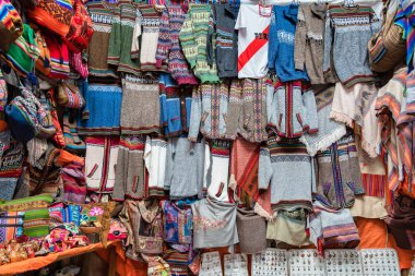 Pisac, Peru - 20 Mart 2025: Pisac pazarındaki geleneksel giysi ve hediyelik eşya dükkanları (Mercado Artesanal de Pisac )