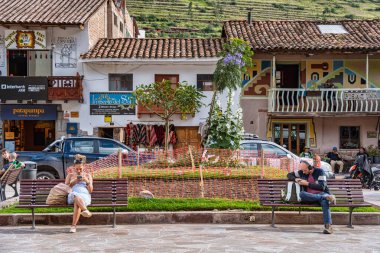 Pisac, Peru - 20 Mart 2025: Pisac 'ın ana meydanında (Plaza Constitucion) dinlenen iki turist