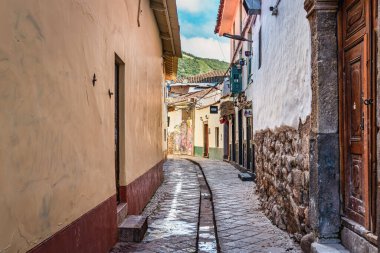 Cusco, Peru - 22 Mart 2025: San Blas 'ın esnaf mahallesinde dar bir kaldırım taşı caddesi ve merdiven manzarası