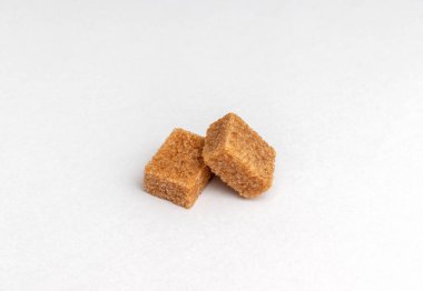 Kahverengi kamış şeker küpleri beyaz arkaplanda izole