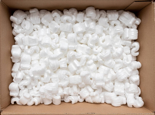 A cardboard box with packing styro foam pellets top view
