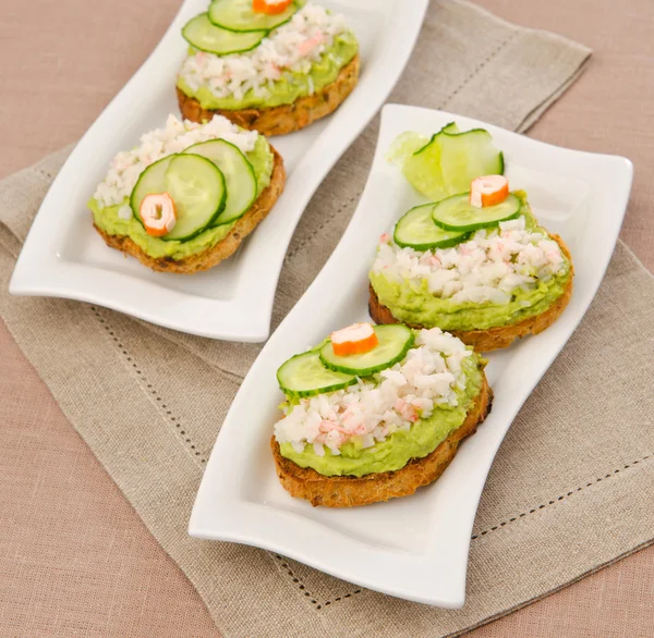 Tostadas con palitos de cangrejo de aguacate guacamole — Foto de Stock