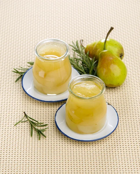Canned pear compote in jar with rosemary