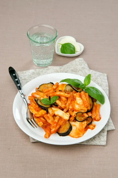 Pâtes avec mozzarella aux aubergines dans une sauce tomate au basilic — Photo