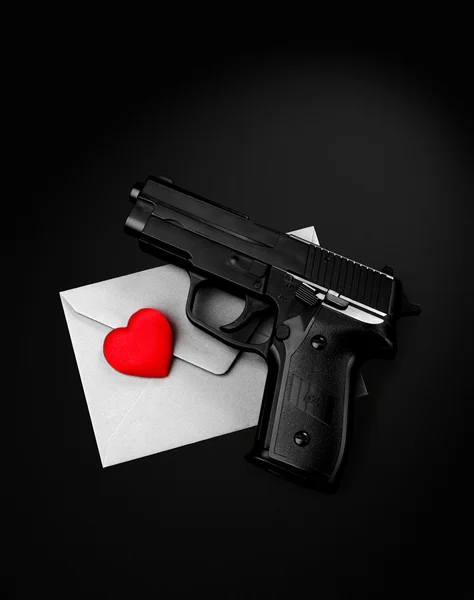 Pistol red heart silver envelope on a black background — Stock Photo, Image