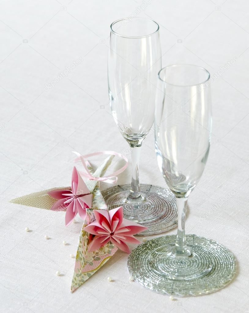 Decoration of festive table origami flowers near wine glasses