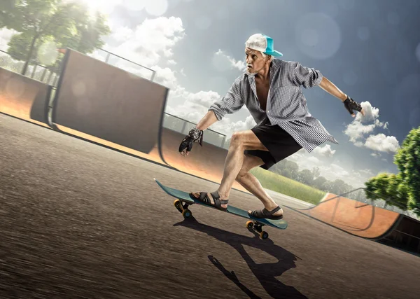 The old man is skating on skateboard — Stock Photo, Image