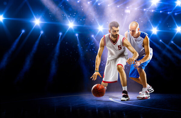 Two basketball players in spotlights