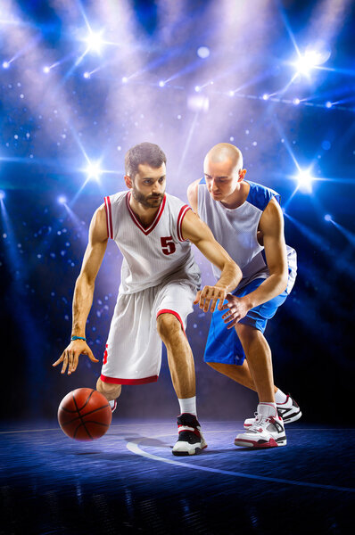 Two basketball players in spotlights