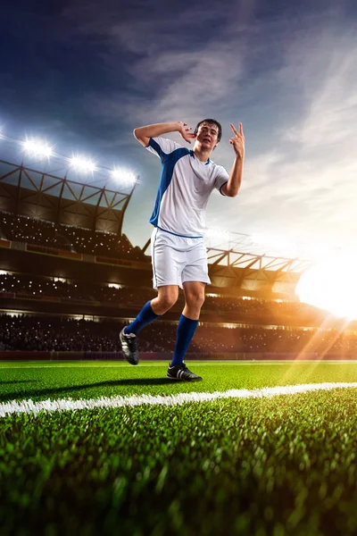 Jogador de futebol em ação por do sol — Fotografia de Stock