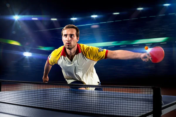 Young sports man tennis player playing on black background with lights — Stock Photo, Image