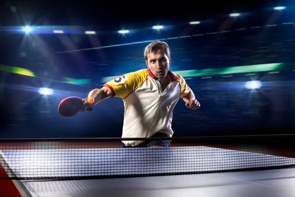 Young sports man tennis player playing on black background with lights — Stock Photo, Image