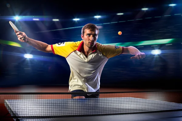 Young sports man tennis player playing on black background with lights — Stock Photo, Image