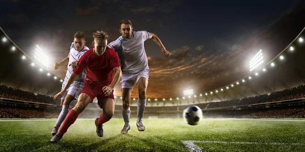 Les joueurs de football en action sur le coucher du soleil panorama arrière-plan du stade — Photo