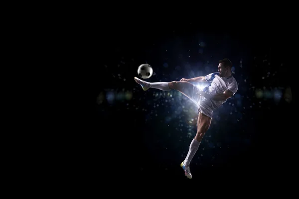 Giocatore di calcio in azione su sfondo nero — Foto Stock