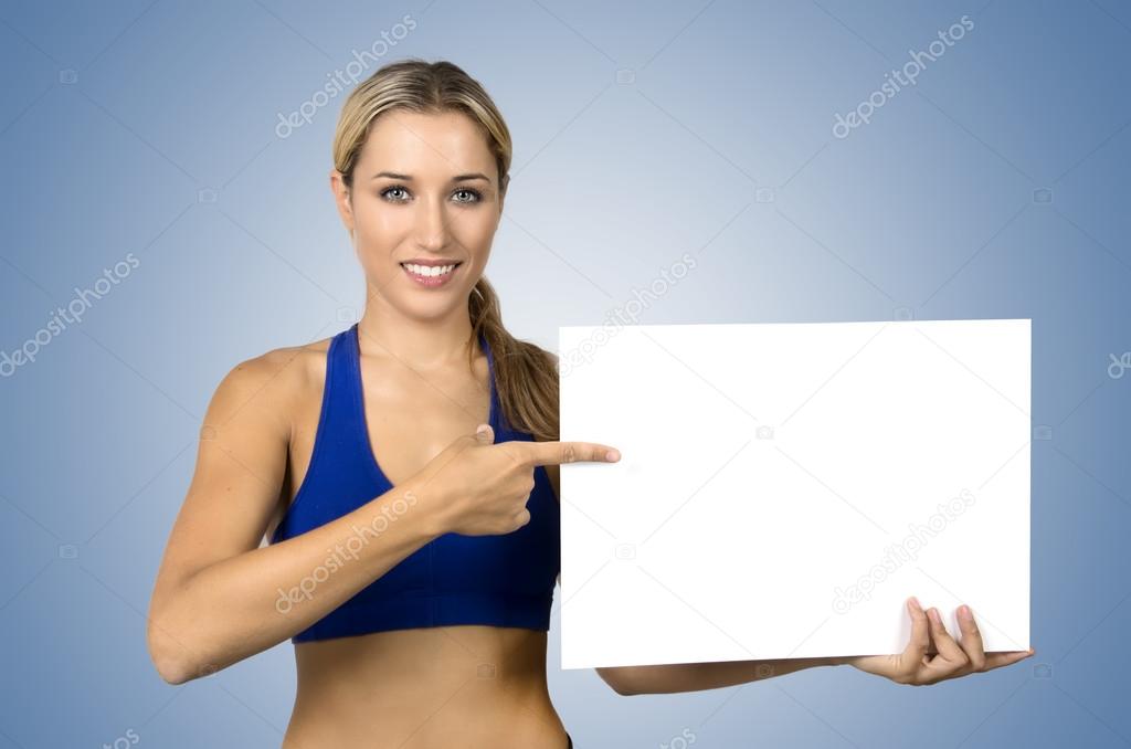 young sportswoman holding blank board and pointing on it 