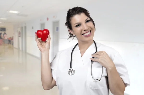 Jovem médico sorridente com pequeno coração vermelho — Fotografia de Stock