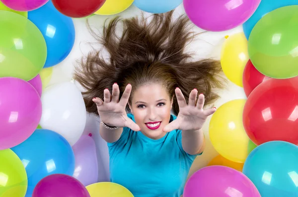 Vrouw omgeven door kleurrijke ballonnen — Stockfoto