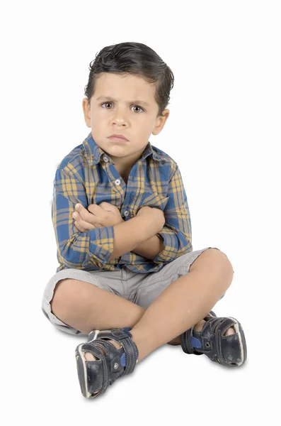 Сердитый ребенок, сидящий на полу — стоковое фото