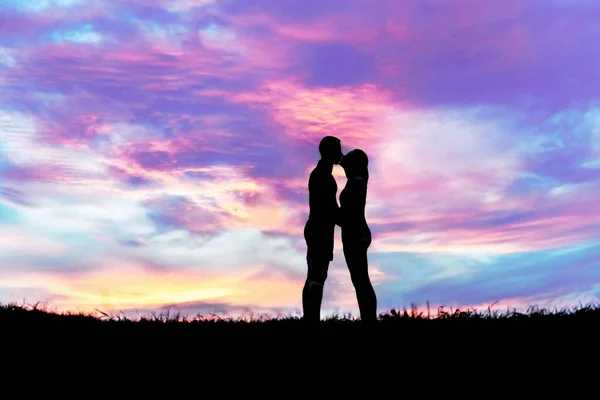 Pareja de silueta sobre hierba con fondo de atardecer —  Fotos de Stock