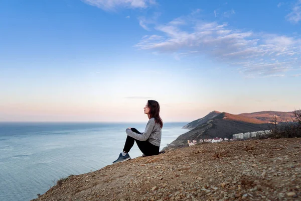 Woman looking on sea in the mountains