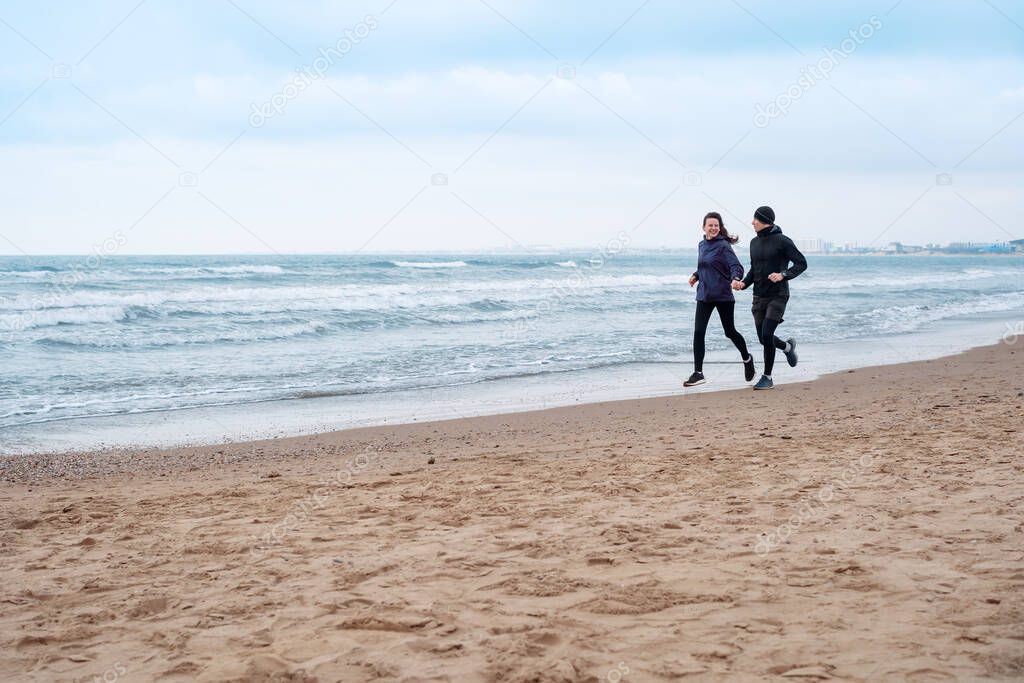 couple running along Beach on the morning