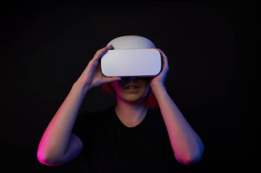 Sanal gerçeklik kulaklığı takan bir kadın. Sanal gerçeklik, oyunlar, eğlence ve iletişim kavramı.