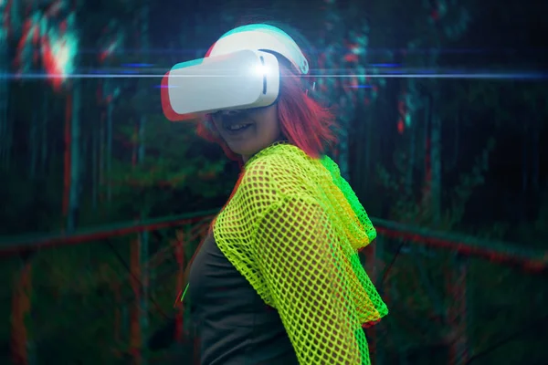 Femme va dans la réalité virtuelle en utilisant casque de réalité virtuelle. Image avec effet de pépin. — Photo