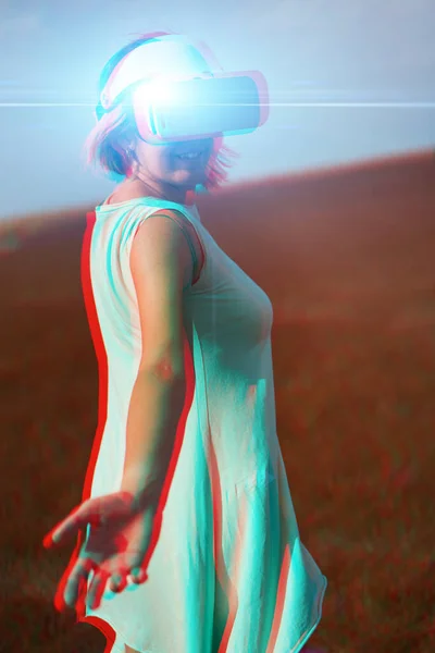 Woman goes into virtual reality using virtual reality headset. Image with glitch effect. — Stock Photo, Image