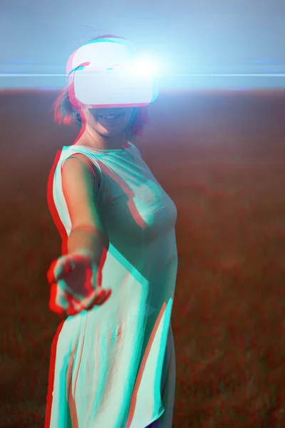 Femme va dans la réalité virtuelle en utilisant casque de réalité virtuelle. Image avec effet de pépin. — Photo