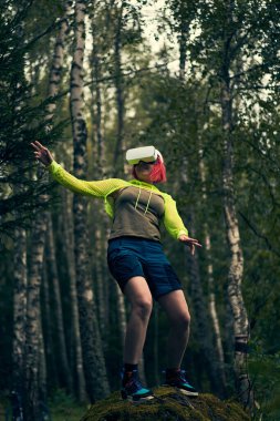 Kadın sanal gerçekliğe sanal gerçeklik kulaklığı kullanarak giriyor..