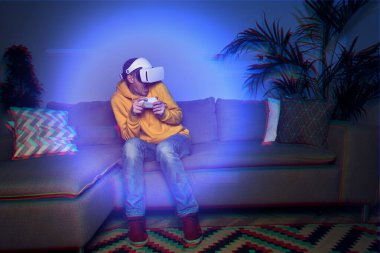 Adam evde vr kulaklık kullanarak oyun oynuyor