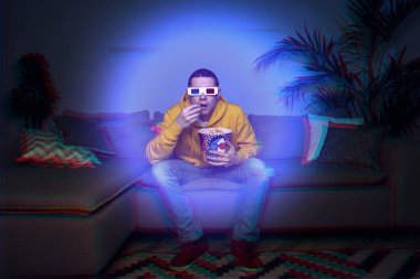Evinde 3D gözlüklü bir adam 3 boyutlu film izliyor.