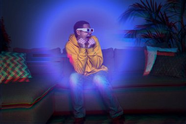 Evinde 3D gözlüklü bir adam 3 boyutlu film izliyor.