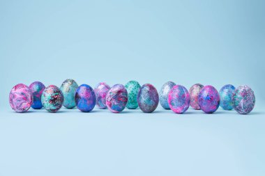 Mavi arka planda renkli parlak yumurtalar.