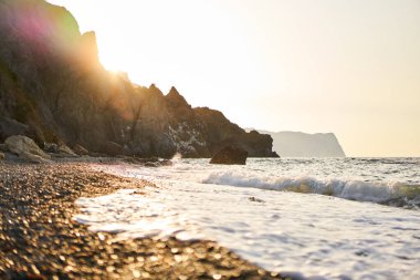 Güneş doğarken Cape Fiolent 'teki Jasper plajında dalgalar