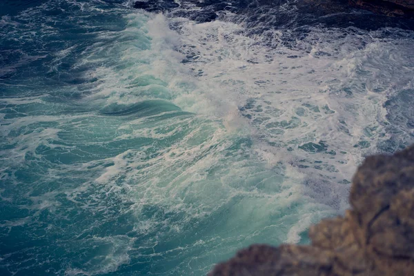 Las olas del mar chocan contra la costa rocosa —  Fotos de Stock