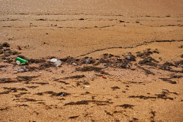 해변에 버려진 쓰레기 - 사용되지 않은 더러운 플라스틱 병, 포장 물 및 기타 가정용 쓰레기. — 스톡 사진