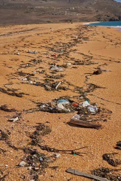 Verter basura en la playa: botellas de plástico sucias usadas vacías, paquetes y otros desechos domésticos. — Foto de Stock